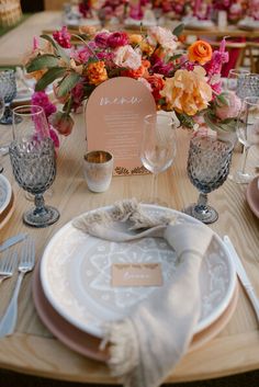 the table is set with place settings and flowers