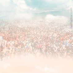 a large group of people standing in the middle of a field under a cloudy sky