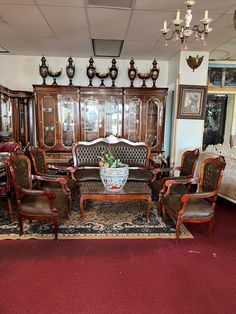 a living room filled with lots of furniture and decor on top of a red carpet