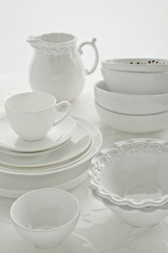 white dishes and cups are arranged on a table