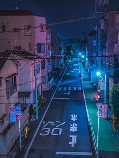 an empty city street at night with the lights on