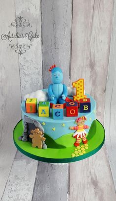 a birthday cake decorated with toys and letters