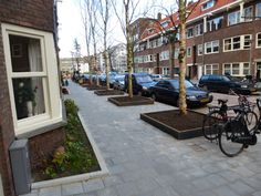 there are many cars parked on the side of the street next to each other in front of some buildings