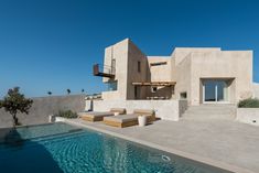 a house with a swimming pool in front of it and an outdoor lounge area next to it