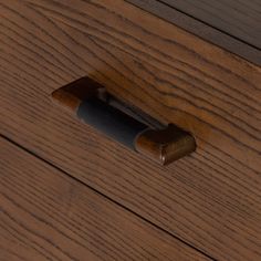 a close up of a wooden drawer with a metal handle