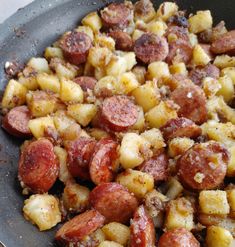 a pan filled with cooked potatoes and sausage