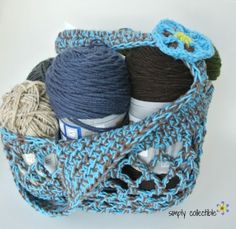 a crocheted basket filled with yarn and balls of yarn