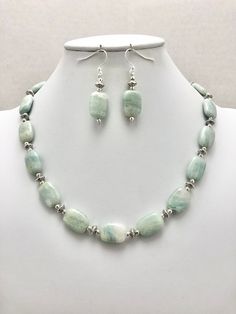 DESCRIPTION:  This beaded necklace features a strand of aquamarine rectangle-shaped beads spaced with tiny round silver pewter beads and tiny silver pewter saucer-shaped beads. I kept the design extremely simple to keep the focus on the aquamarine nuggets. The aquamarine beads are a soft blue color with white inclusions in the stone--it is reminiscent of clouds against a pale blue sky or the white caps on ocean waves! Each bead is so unique and lovely. The tiny silver beads adds a decorative det Elegant Aquamarine Faceted Beads Jewelry, Elegant Aquamarine Jewelry With Faceted Beads, Elegant Beaded Amazonite Jewelry, Blue Single Strand Amazonite Jewelry, Aquamarine Round Beads Jewelry With Natural Stones, Blue Amazonite Single Strand Jewelry, Blue Amazonite Jewelry With Single Strand, Aquamarine Faceted Beads Jewelry, Elegant Amazonite Jewelry With Faceted Beads