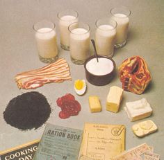 an assortment of food and drinks sitting on a table next to each other, including eggs, bacon, cheese, milk, bread, butter, and cookies