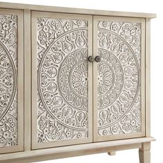 an ornate white cabinet with carvings on the doors and drawer pulls is shown against a white background