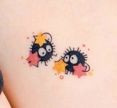 two small tattoos on the back of a woman's stomach, one with stars