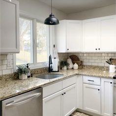 a clean kitchen with white cabinets and granite counter tops is seen in this image from the front view