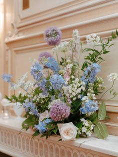 a bunch of flowers that are sitting on a mantle