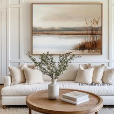 a living room filled with furniture and a large painting on the wall above it's coffee table