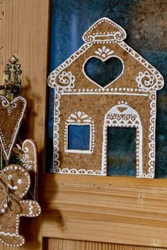 two gingerbread house shaped cookies are on the shelf next to each other, and one is decorated with an ornament in the shape of a gingerbread