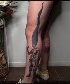 a man's legs with tattoos on them and an image of a woman holding a cat