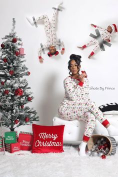 a woman in christmas pajamas sitting on a white couch