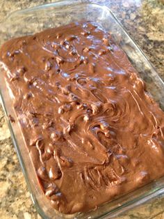 a glass dish filled with chocolate frosting on top of a counter