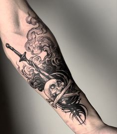 a person with a tattoo on their arm holding a knife and skull in the air