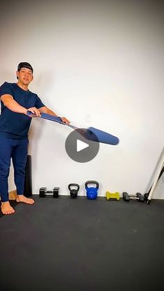 a man holding a blue frisbee while standing in front of a white wall