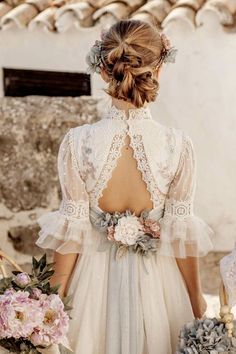 the back of a woman's dress with flowers in her hair