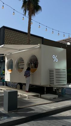 a man standing in front of a mobile home with an percentage sign on it's side