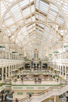 the inside of a large building with lots of windows and people on escalators