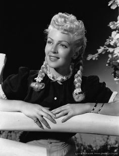 a black and white photo of a woman with her arms crossed