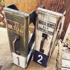 two old fashioned gas pumps sitting on top of a burlick covered table next to each other