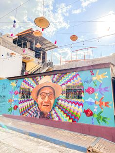 a large mural on the side of a building with a man wearing a hat and glasses