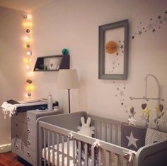 a baby's room with a crib and lights on the wall