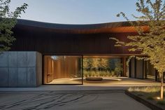 the entrance to a modern home surrounded by trees