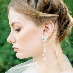 a woman with her hair in a bun and earrings