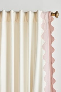 a curtain with scalloped edges hanging on a wall next to a white wall