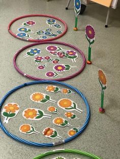 several colorful flower designs are on the floor next to some plastic hoops and poles