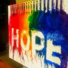 the word hope is painted on a wall with multicolored paint splatters