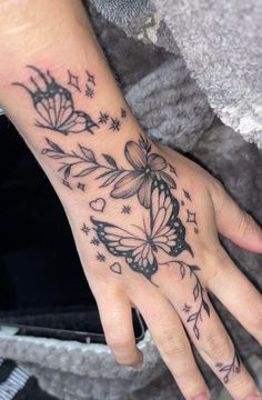 a woman's hand with a butterfly tattoo on it