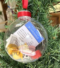 a christmas ornament hanging from a tree filled with money and other items that are on top of it