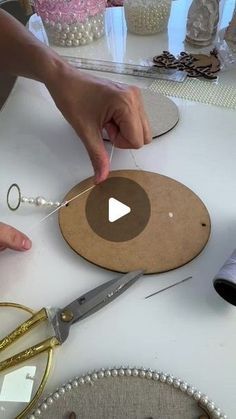 a person is cutting up some paper on a table with scissors and other crafting supplies