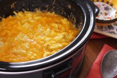 a crock pot filled with macaroni and cheese on top of a table