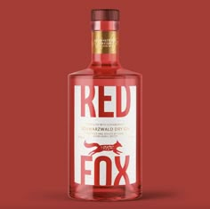 a bottle of red fox gin on a red background with the word's logo