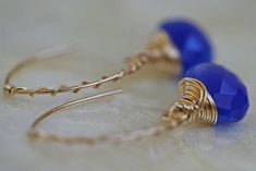 "Chalcedony open hoop earrings in cobalt blue and 14k gold fill. An elegant hand formed 14k gold filled arc shaped ear wire, made to look like a hoop earring, is wrapped with fine gauge 14k gold filled wire in a candy cane twist. Faceted cobalt blue chalcedony hangs from the ear wire. The heart shaped brioletts are lavishly wrapped in more 14k gold filled wire. Earrings hang approximately 1 1/2 \" (40mm) See more briolette dangle earrings here: http://www.etsy.com/shop/LHJewelryBoutique/search?s Blue Wire Wrapped Hoop Earrings For Gift, Blue Wire Wrapped Hoop Earrings As Gift, Handmade Blue 14k Gold-filled Earrings, Handmade Blue 14k Gold Filled Earrings, Handmade 14k Gold Filled Blue Earrings, Blue 14k Gold-filled Earrings, Blue Nickel-free 14k Gold-filled Hoop Earrings, Handmade Blue Hoop Earrings In 14k Gold Filled, Handmade Blue 14k Gold Filled Hoop Earrings