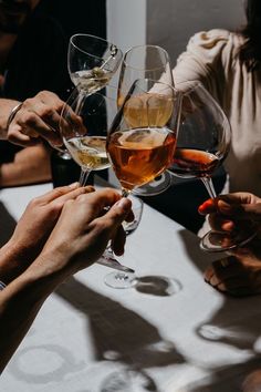 several people are toasting with wine glasses