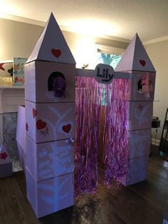 a cardboard castle with purple streamers and hearts on it