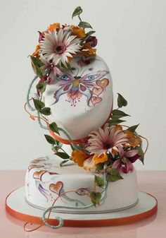 a three tiered cake decorated with flowers and leaves