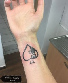 a person with a tattoo on their arm holding up a card