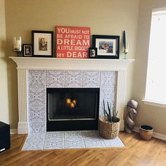 a living room with a fire place and pictures on the fireplace mantel above it