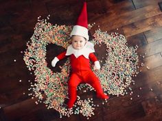 an elf laying on the floor surrounded by sprinkles