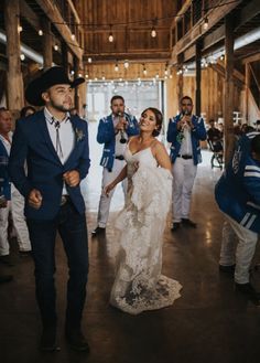 a bride and groom walking through the barn