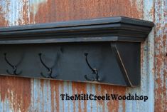 an old metal shelf with hooks on it and rusted paint behind the coat rack